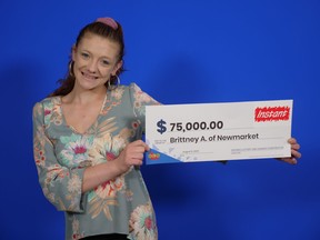 Woman holding big $75,000 cheque.