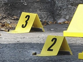 Shell casings can be seen beside police markers on Spadina Ave. that claimed the life of a man in his 40s.