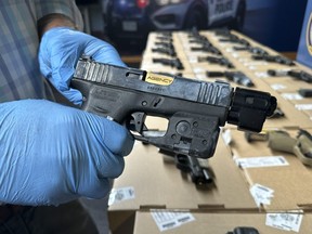During a news conference on Monday, Aug. 28, Toronto Police display 28 handguns seized.