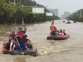 Residents are evacuated by rubber boats through flood waters in Zhuozhou
