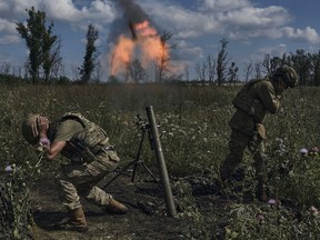 Ukrainian soldiers fire a mortar towards Russian positions at the front line, near Bakhmut, Donetsk region, Ukraine, Saturday, Aug. 12 2023.