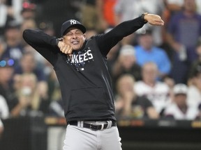 New York Yankees manager Aaron Boone imitates an umpire calling strike three after arguing with home plate umpire Laz Diaz during the eighth inning of a baseball game against the Chicago White Sox Monday, Aug. 7, 2023, in Chicago.