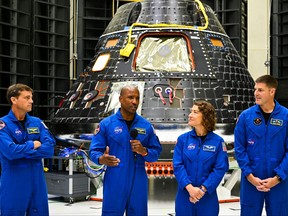 The crew of Artemis II (left to right) U.S. astronauts Reid Wiseman, commander; Victor Glover, pilot; Christina Hammock Koch, mission specialist; and Canadian astronaut Jeremy Hansen, mission specialist, speak in front of the Artemis II crew module (rear) inside the Neil Armstrong Operations and Checkout Building at the Kennedy Space Center in Cape Canaveral, Fla., on Aug. 8, 2023.
