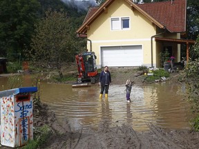 A dad and his daughter stand in the flooded garden