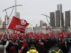 Supporters for Unifor, the national union representing auto workers, attend a rally within view of General Motors headquarters, background, in Windsor, Ont., Friday, Jan. 11, 2019.