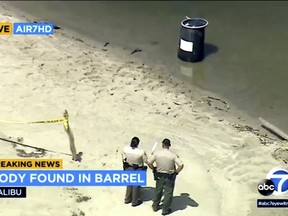 law enforcement officers standing by a barrel at Malibu Lagoon