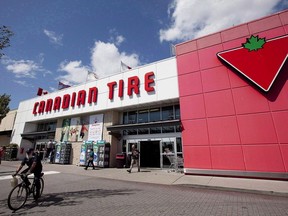 Canadian Tire Corp. Ltd. is reporting a drop in earnings and revenue as inflation tamps down consumer demand for discretionary goods.A man cycles by a Canadian Tire store in Vancouver on May 10, 2012.
