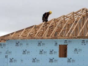 A construction worker works on a house in a new housing development in Oakville, Ont., Friday, April 29. 2011.