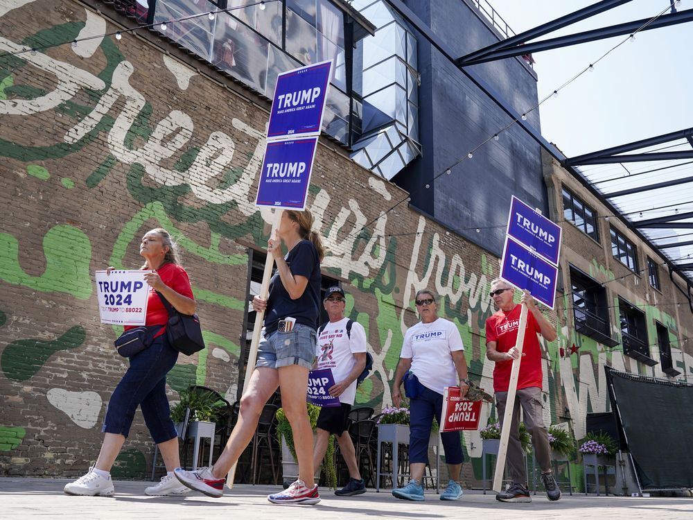 Former president Donald Trump supporters walk near the Fiserv Forum as set up continues for the upcoming Republican presidential debate Tuesday, Aug. 22, 2023, in Milwaukee.