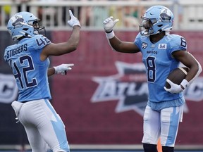 Toronto Argonauts DaShaun Amos, right, celebrates his touchdown with teammate Qwan'tez Stiggers during the second half of CFL action against the Saskatchewan Roughriders in Halifax on Saturday, July 29, 2023.