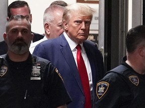 Former U.S. president Donald Trump is escorted to a courtroom.