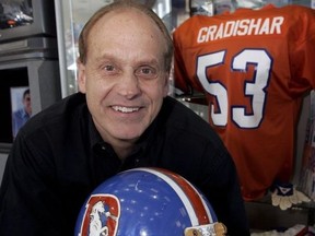 Former Denver Broncos linebacker Randy Gradishar holds one of his football helmet.