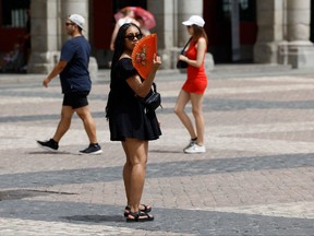 A woman fans herself to cool off in the midst of a heat wave in Madrid on Aug. 9, 2023