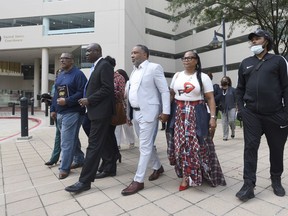Attorney Ben Crump, second from left, walks with Ron Lacks, left, Alfred Lacks Carter, third from left, both grandsons of Henrietta Lacks