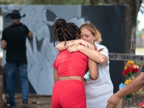 April Sizemore comforts a Dollar General store employee who witnessed a mass shooting at the store two days earlier on Aug. 28, 2023 in Jacksonville, Fla.