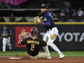 J.P. Crawford of the Seattle Mariners tags Xander Bogaerts of the San Diego Padres at second base during the sixth inning at T-Mobile Park on Aug. 9, 2023 in Seattle, Washington.
