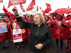 Unifor National President Lana Payne leads a chant in front of striking employees of the grocery store Metro are seen on the picket lines in Toronto, on Wednesday, Aug. 23, 2023.
