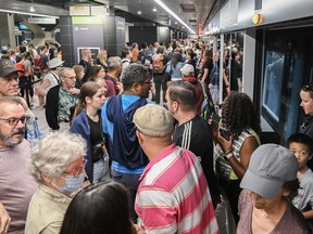 People enter and exit a Réseau express métropolitain (REM) light-rail train at Central Station in Montreal, Saturday, July 29, 2023.