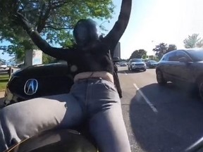 Screenshot from dash cam footage of woman on motorcycle getting rear-ended by SUV.