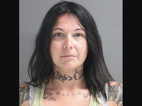 Mugshot of woman with tattoos.