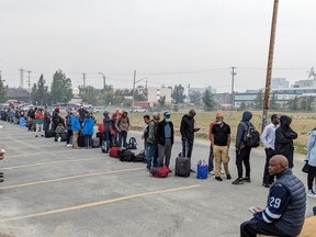 People without vehicles lineup to register for a flight to Calgary in Yellowknife on Thursday, Aug. 17, 2023.