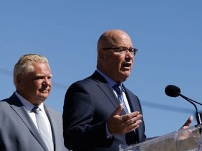 Ontario Premier Doug Ford listens as Clark speaks during a press conference in Mississauga Friday, Aug. 11, 2023.