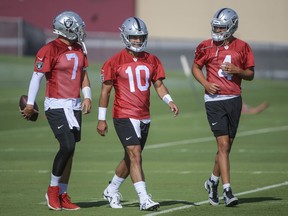 Las Vegas Raiders quarterbacks Brian Hoyer (7), Jimmy Garoppolo (10), and Aidan O'Connell (4) talk during practice at the NFL football team's training camp, Saturday, July 29, 2023, in Henderson, Nev.