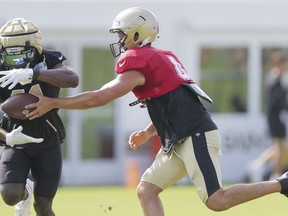 New Orleans Saints quarterback Derek Carr (4) hands the ball to Saints running back Alvin Kamara (41) during a drill at NFL football training camp practice in Metairie, La., Monday, July 31, 2023.