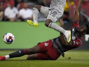 Toronto FC defender Aimé Mabika (6) slide tackles as CF Montréal midfielder Kwadwo Opoku jumps towards the ball during first half MLS soccer action in Toronto on Sunday Aug. 20, 2023.
