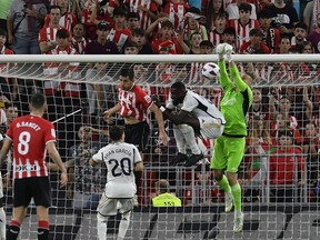 Real Madrid's goalkeeper Andriy Lunin, right, clears the ball during the Spanish La Liga soccer match between Athletic Club and Real Madrid at the San Mames stadium in Bilbao, Spain, Saturday, Aug. 12, 2023.