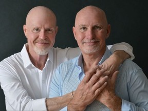 Two bald men with arms around each other