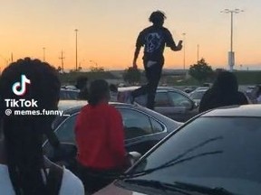A youth is seen walking on top of a parked vehicle at Yorkdale Mall.
