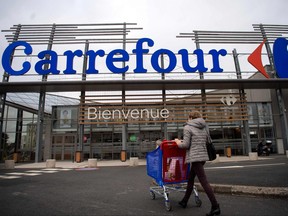 A woman enters a Carrefour surpermarket.