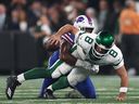 Quarterback Aaron Rodgers of the New York Jets is sacked by defensive end Leonard Floyd of the Buffalo Bills.