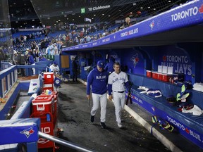 Daulton Varsho of the Toronto Blue Jays leaves the dugout with hitting strategist Dave Hudgens after a 10-0 loss to the Texas Rangers.