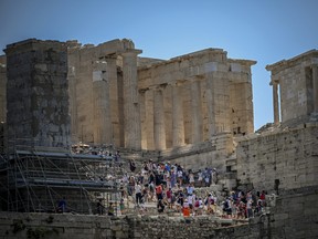 Tourists visit the Ancient Acropolis archeological site in Athens on July 13, 2023.