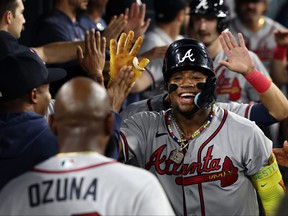 Ronald Acuna Jr. #13 of the Atlanta Braves celebrates his grand slam home run in the dugout with teammates during the second inning at Dodger Stadium on August 31, 2023 in Los Angeles, California. (Photo by Kevork Djansezian/Getty Images)