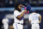 Vladimir Guerrero Jr. #27 of the Toronto Blue Jays puts on his hat after hitting a pop fly to end the sixth inning of their MLB game against the Texas Rangers at Rogers Centre on September 13, 2023 in Toronto. (Photo by Cole Burston/Getty Images)