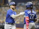 Blue Jays' Bo Bichette (left) is greeted at home by teammate Vladimir Guerrero Jr. after Bichette's ninth-inning home run agains the Tampa Bay Rays at Tropicana Field on Sept. 24, 2023 in St Petersburg.