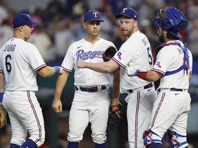 From left, Josh Jung of the Texas Rangers, Nathaniel Lowe, Will Smith, and Austin Hedges celebrate after the 15-5 victory against the Boston Red Sox at Globe Life Field on Sept. 20, 2023 in Arlington, Texas.
