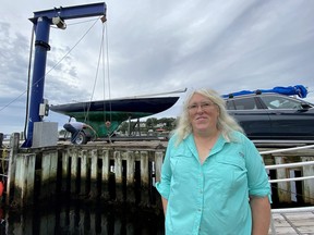 A boater removes a sailboat from the wharf in Chester harbour in anticipation of the arrival of hurricane Lee, as Jennifer Chandler, commodore of the Chester Yacht Club in Chester, N.S., poses for a photo, Friday, Sept. 15, 2023.