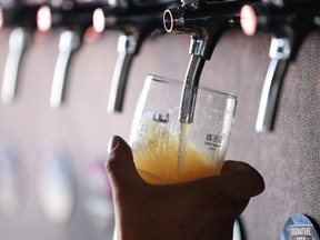 A bartender pours a beer from a tap, at Signature Brew brewery, in East London, Aug. 19, 2022.