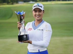 Minjee Lee holds a trophy.