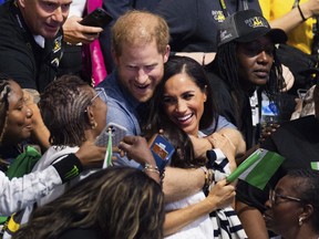 Prince Harry and Meghan, The Duchess of Sussex, watch sitting volleyball between fans from Nigeria and Ukraine at the 6th Invictus Games in Duesseldorf, Germany, Thursday, Sept. 14, 2023. (Rolf Vennenbernd/dpa via AP)