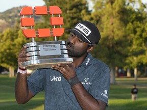 Sahith Theegala kisses a trophy.