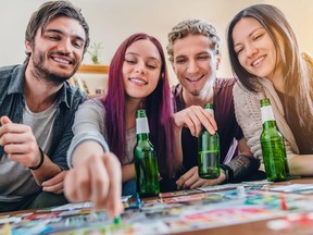 Group of friends playing board games on the table at home