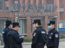 Security personnel stand guard outside the Wuhan Institute of Virology in Wuhan as members of the World Health Organization (WHO) team investigating the origins of the COVID-19 coronavirus make a visit to the institute in Wuhan in China's central Hubei province on February 3, 2021.
