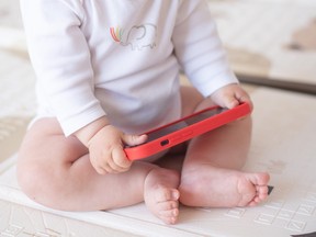 Baby holding a cellphone.