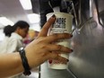 A customer fills a 21 ounce cup with soda at a McDonalds