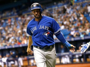 Chris Colabello #15 of the Toronto Blue Jays (L) after scoring during the second inning of a game against the Tampa Bay Rays.